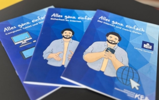 Drei Broschüren mit blauem Cover liegen auf einem Tisch. Die Titel lauten: „Alles ganz einfach – Computer, Tablet und Smartphone“, „Alles ganz einfach – Sicherheit im Internet“ und „Alles ganz einfach – Das Internet und meine Daten“. Die Broschüren sind in Leichter Sprache und zeigen gezeichnete Figuren auf den Covern.