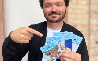 Eine Person hält mehrere Pixi-Hefte der Reihe Die Daten-Füchse in der Hand und zeigt darauf. Die bunten Hefte behandeln Themen wie Datenschutz, Informationsfreiheit und Privatsphäre.